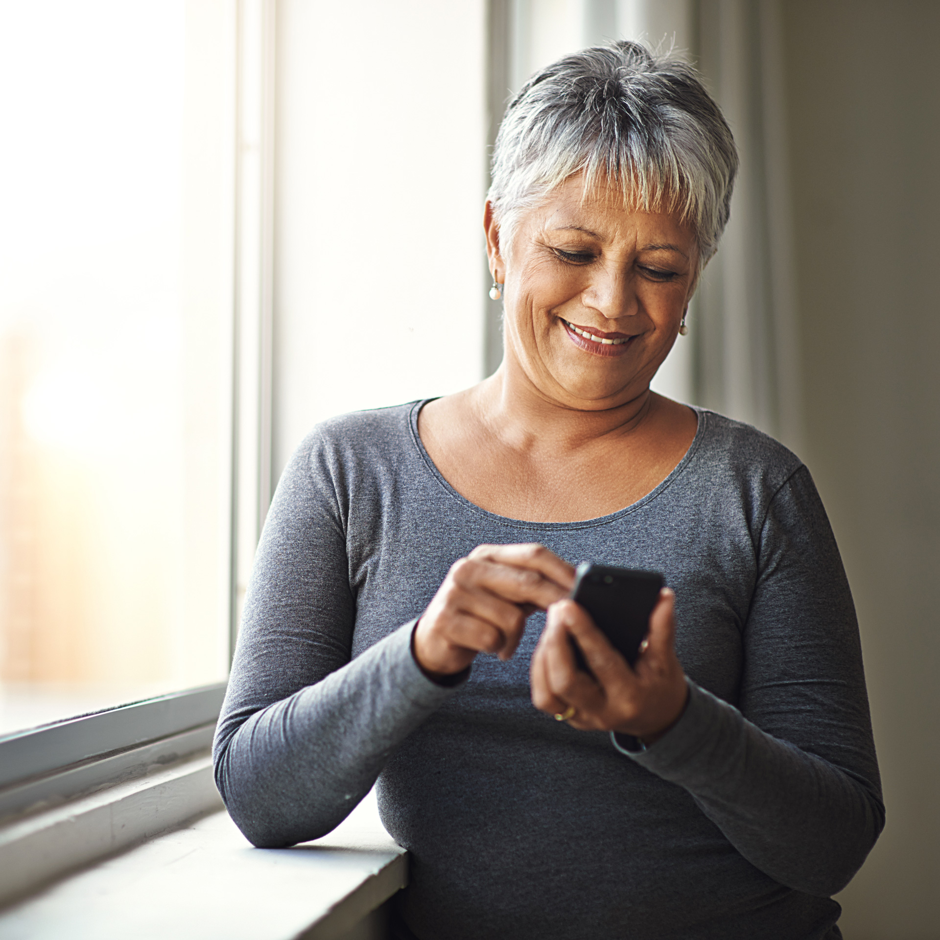 Woman on her phone next to a window